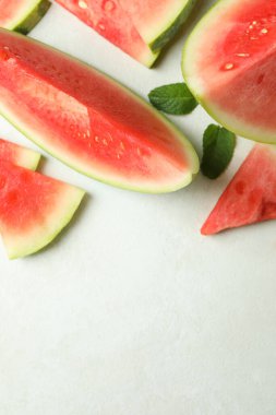 Karpuz dilimleri ve beyaz desenli masada nane yaprakları.