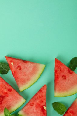 Sulu karpuz dilimleri ve nane arkaplanda yapraklar