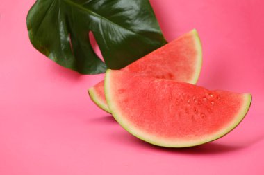 Pembe arka planda karpuz dilimleri ve palmiye yaprağı