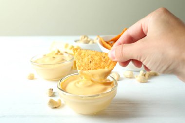 Kadın elini peynir sosuna daldırıyor, yakın çekim.