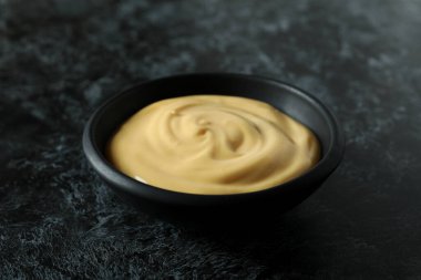 Siyah dumanlı arka planda peynir soslu kase