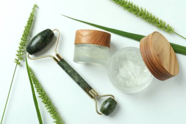 Beyaz arka planda yeşil yüz silindirli cilt bakımı kavramı