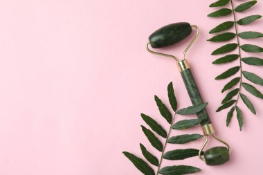 Yeşil yüz silindiri ve pembe arkaplanda yapraklar