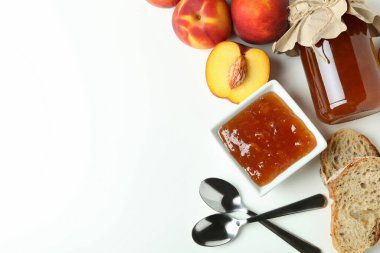 Beyaz arkaplanda şeftali reçeli ve malzemeler