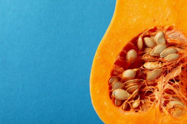 Mavi arkaplanda işlenmemiş balkabağının yarısı