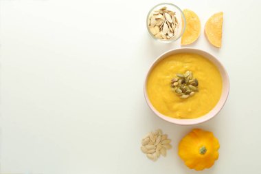 Beyaz arka planda balkabağı çorbası malzemeleriyle bembeyaz yatıyordu