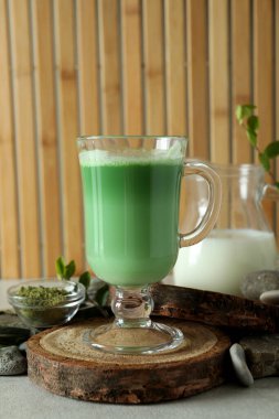 Bambu arka planına karşı yapılan matcha latte ve aksesuarlar.