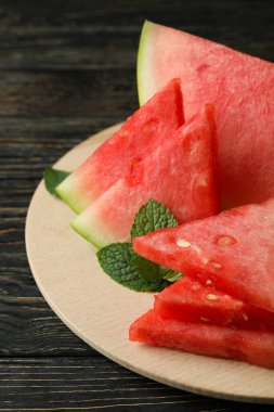 Karpuz dilimleri ve nane yapraklı ahşap tahta.
