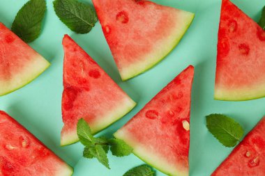 Sulu karpuz dilimleri ve nane arkaplanda yapraklar