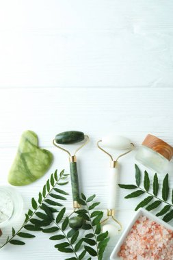 Beyaz ahşap arka planda yüz silindirli cilt bakımı kavramı