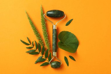 Yeşil yüz silindiri ve turuncu arkaplanda yapraklar