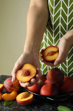 Yeşil önlüklü kız olgun şeftali meyveleri tutuyor.