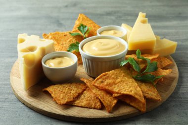Peynir soslu, cipsli, peynirli ve maydanozlu masa.