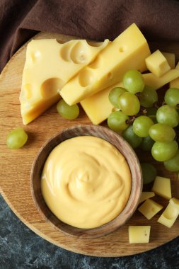 Peynir soslu, üzümlü ve peynirli pano siyah dumanlı masa ve mutfak havlusu.