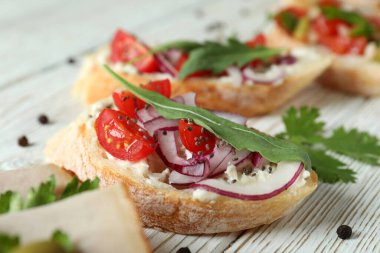 Lezzetli İtalyan atıştırmalıkları beyaz ahşap arka planda bruschetta