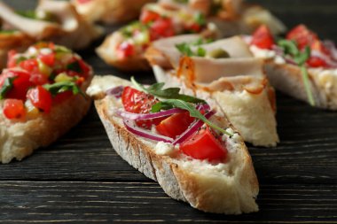 Lezzetli İtalyan atıştırmalıkları ahşap arka planda bruschetta.