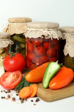 Kavanozlar dolusu sebze turşusu ve malzemeler beyaz masada.