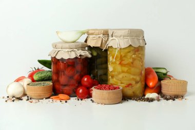 Kavanozlar dolusu sebze turşusu ve malzemeler beyaz masada.