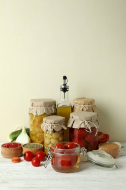 Kavanozlar dolusu sebze turşusu ve beyaz ahşap masa malzemeleri.
