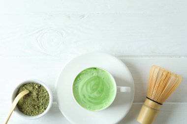 Beyaz ahşap masa için kibrit latte ve aksesuarlar.