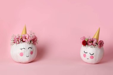 Pembe arka planda cadılar bayramı makyajı olan şirin balkabakları.