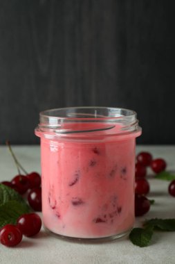 Cam kavanoz vişneli smoothie ve beyaz desenli masa malzemeleri.