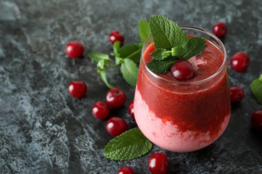 Bir bardak vişneli buzlu içecek ve siyah dumanlı masa malzemesi.