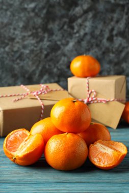 Mandalina ve hediye kutuları ahşap masada.