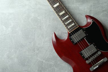 Gri dokulu arka planda kırmızı elektro gitar