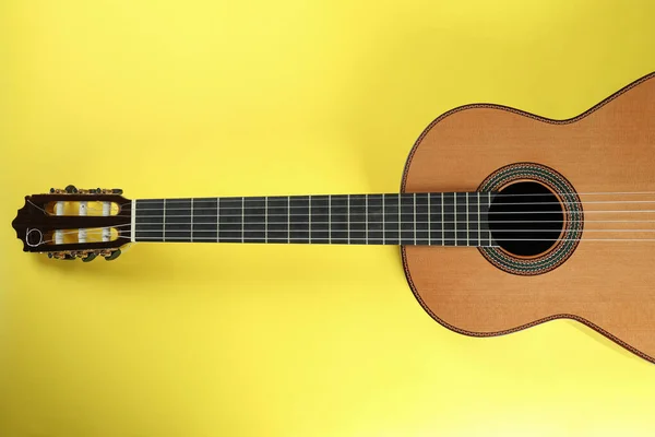 黄色の背景のクラシックギター トップビュー — ストック写真