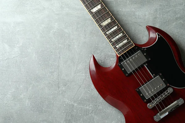 灰色纹理背景的红色电吉他 — 图库照片
