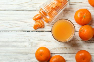 Mandalina reçeli ve malzemeler beyaz ahşap masada.