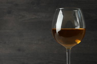 Koyu ahşap arka planda bir bardak beyaz şarap