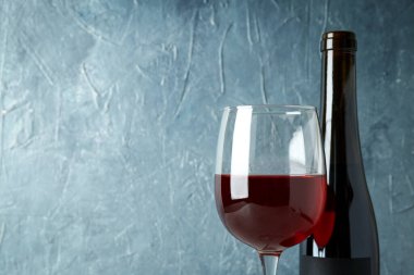 Mavi desenli arka plana karşı bir şişe kırmızı şarap.