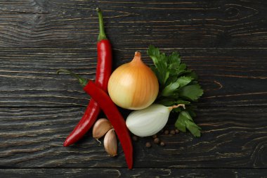 Kırsal ahşap arka planda farklı baharatlı sebzeler.