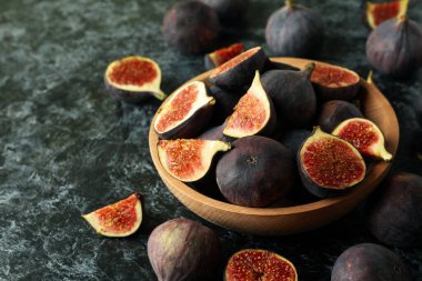 Siyah dumanlı arka planda incirli kase