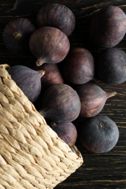 Kırsal ahşap arka planda incirli hasır tencere.