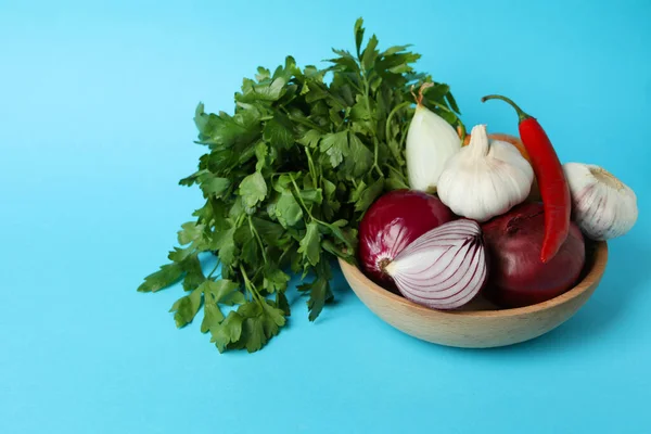 青い背景にスパイシーな野菜とパセリとボウル — ストック写真