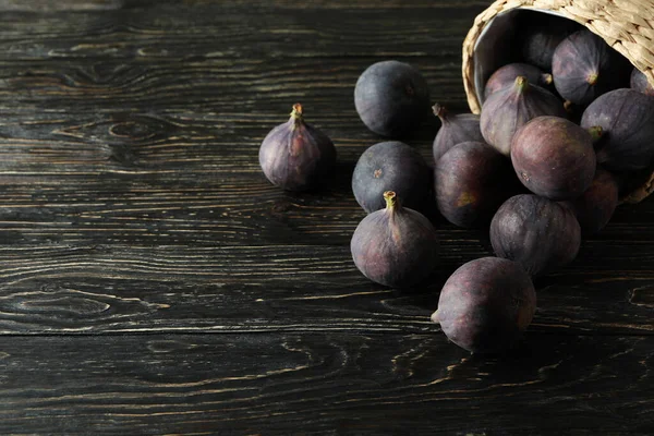 Kırsal ahşap arka planda incirli hasır tencere.