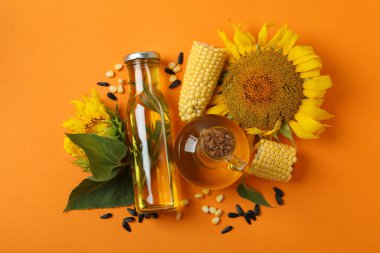 Turuncu arka planda bir şişe yağ ve malzeme.