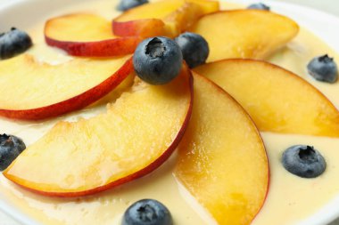 Üzümlü şeftalili yoğurt ve şeftali dilimleri, yakın çekim.