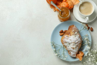Lezzetli kahvaltı kavramı kruvasan, mandalina reçeli ve beyaz desenli masada kahve.