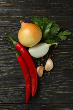 Kırsal ahşap arka planda farklı baharatlı sebzeler.