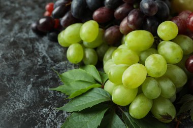 Olgun üzüm ve yapraklar siyah dumanlı arkaplanda