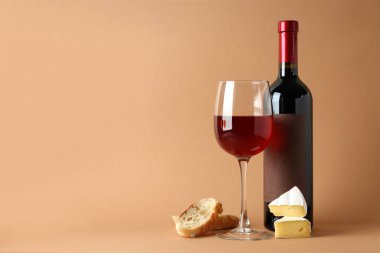 Bej arka planda şarap, peynir ve ekmek.