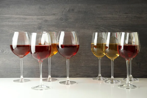 Weingläser Auf Weißem Tisch Vor Hölzernem Hintergrund — Stockfoto