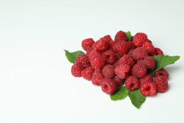 Beyaz arka planda bir avuç kırmızı sulu ahududu..