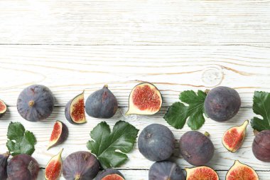 Beyaz ahşap arka planda yaprakları olan incir