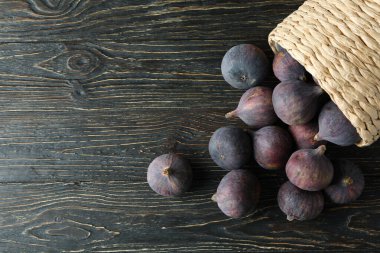 Kırsal ahşap arka planda incirli hasır tencere.