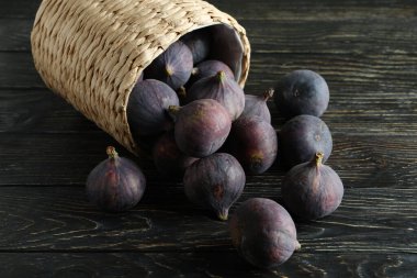 Kırsal ahşap arka planda incirli hasır tencere.